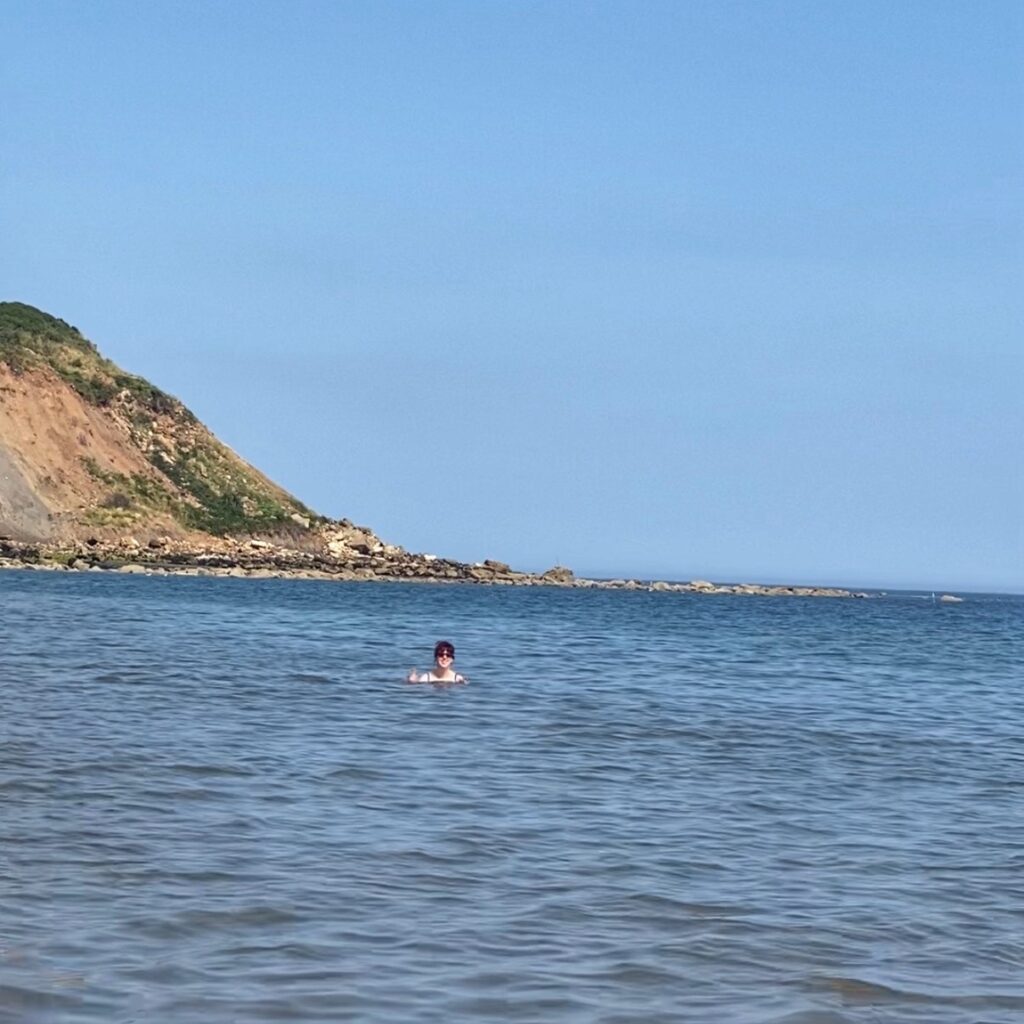 A woman swims in the blue sea.