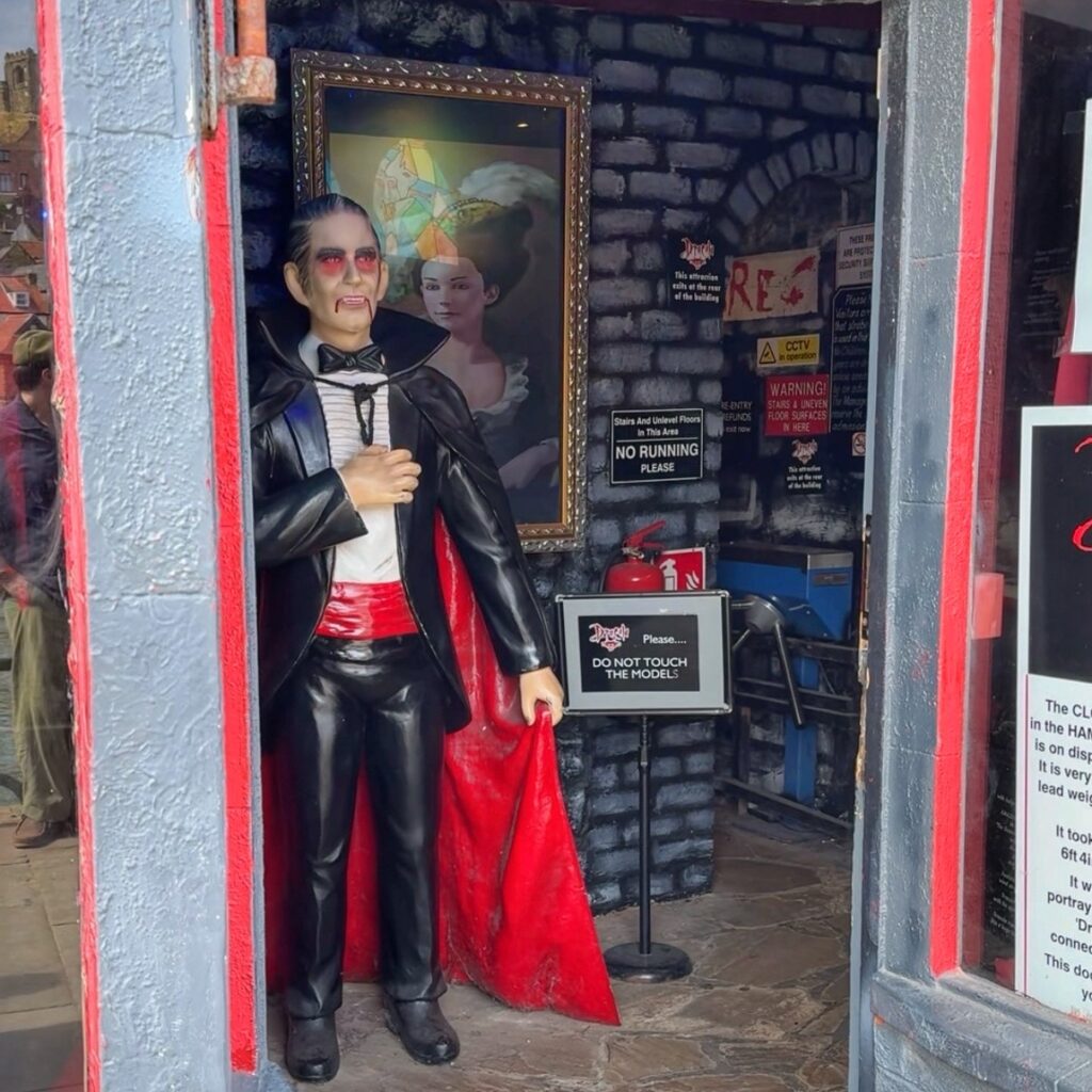 The entrance to a building with a statue of Dracula in a black cape inside